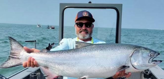 Buoy 10 Fishing Guide Owner Toby Wyatt of ReelTime Fishing Holding up a Huge Coho Salmon